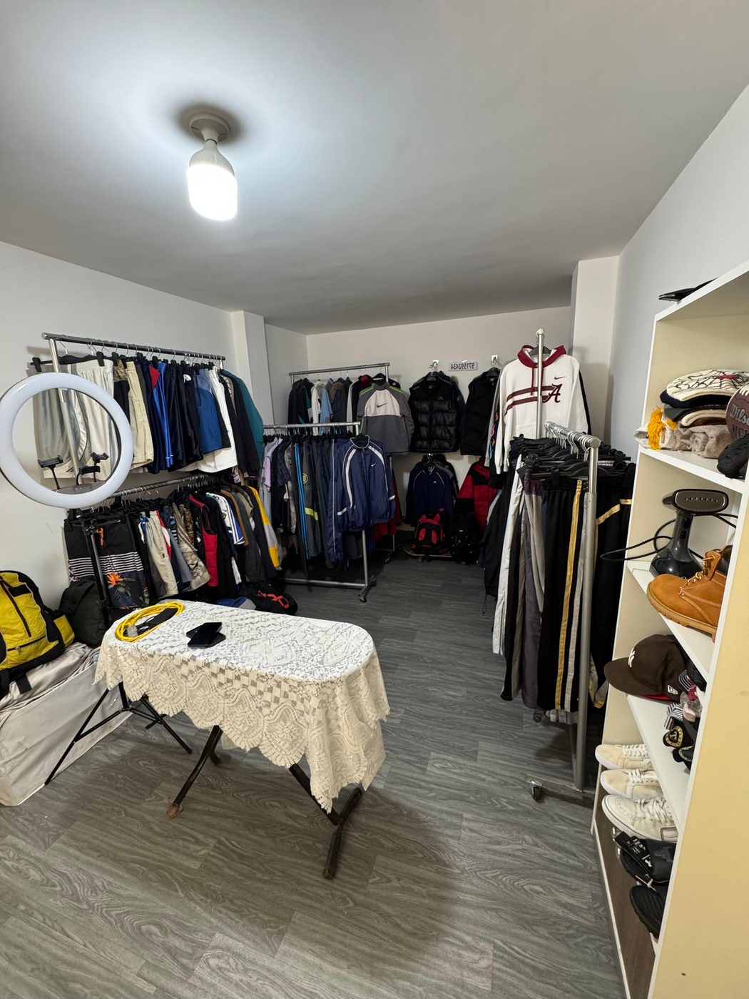 Interior de la tienda Vintage Flame: percheros con casacas, polos y pantalones, y estantes con zapatillas y gorras